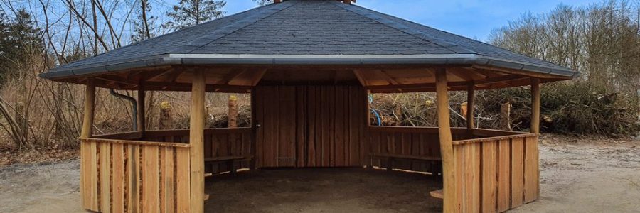 Billede af bålhytte med indhegning til luftige og vindfyldte områder. Kan bruges som madpakkehus eller multihus.